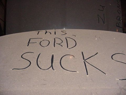 1992 Ford Bronco - Scratched text on a vehicle hood reads "THIS FORD SUCKS" and "ZU BRONCO".