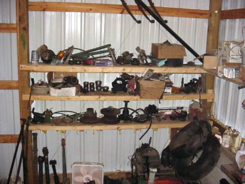 1992 Ford Bronco - A workshop scene displays shelves stocked with numerous automotive parts, such as engine components and tires.