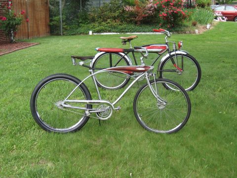 1994 Ford Bronco - Two vintage bicycles are parked on a lawn with a wooden fence and bushes in the background.