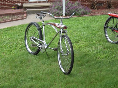 1994 Ford Bronco - A shiny chrome cruiser bicycle with a brown seat and red accents on the frame is displayed on a grassy lawn.