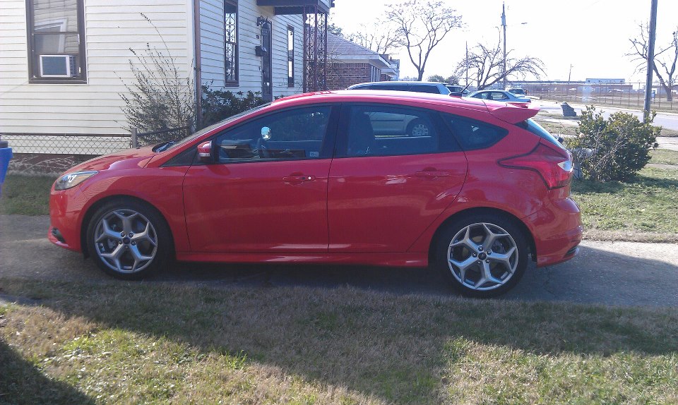 Red 2013 Ford Focus hatchback parked on a lawn