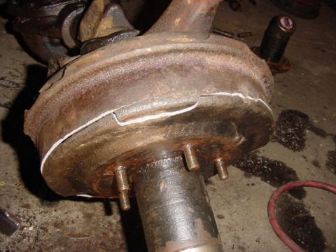 1992 Ford Bronco - Close-up of a heavily rusted brake drum and hub assembly with visible damage.