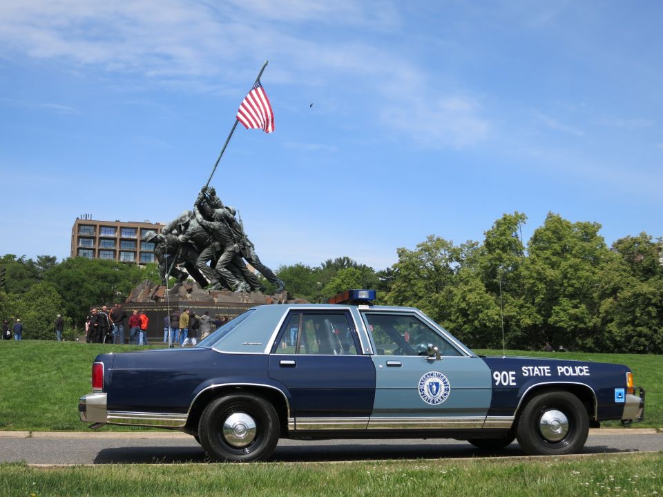 Blue STATE POLICE sedan 90E parked before the Iwo Jima Marine Corps Memorial