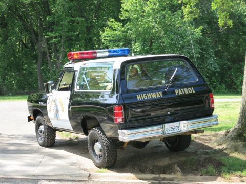 1991 Ford LTD Crown Victoria - black-and-white SUV lettered Highway Patrol with a California plate reading 4Z5938 sits parked near trees.