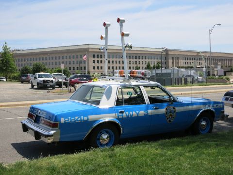 1991 Ford LTD Crown Victoria - Rear quarter of a blue-and-white NYPD Highway patrol sedan with raised floodlight mast parked by the Pentagon.