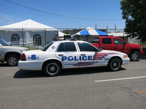 1991 Ford LTD Crown Victoria - white DC Metropolitan Police Ford Crown Victoria patrol car marked POLICE 8666 parked beside event tents.