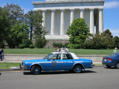 1991 Ford LTD Crown Victoria - vintage blue-and-white NYPD highway patrol sedan with roof lights parked in front of the Lincoln Memorial.