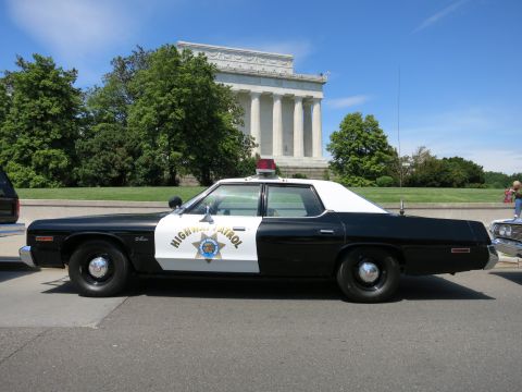 1991 Ford LTD Crown Victoria - black-and-white Highway Patrol full-size sedan with a push bar parked in front of the Lincoln Memorial.