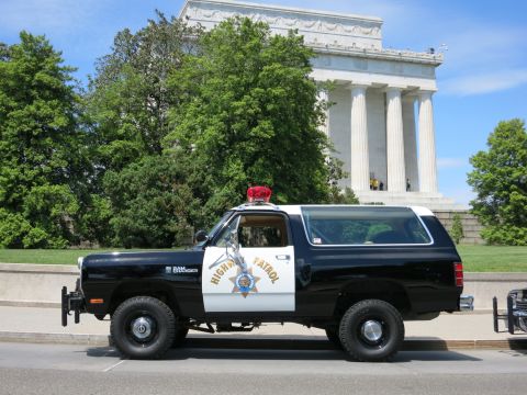 1991 Ford LTD Crown Victoria - black-and-white Highway Patrol SUV with red roof beacon sits before the columned Lincoln Memorial.