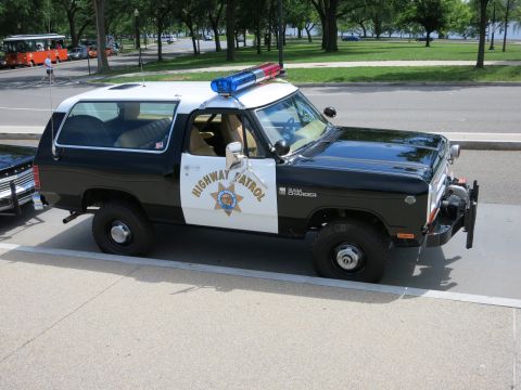 1991 Ford LTD Crown Victoria - black-and-white Highway Patrol SUV badged Ram Charger with winch and light bar shown front three-quarter.