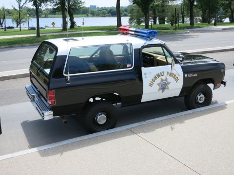 1991 Ford LTD Crown Victoria - Rear three-quarter view of a black-and-white Highway Patrol SUV with light bar parked along a waterfront road.