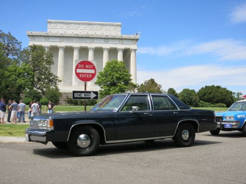 1991 Ford LTD Crown Victoria - dark blue full-size four-door sedan sits before the columned Lincoln Memorial near a Do Not Enter sign.