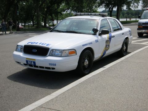 1991 Ford LTD Crown Victoria - Front three-quarter view of a white Philadelphia Police Ford Crown Victoria marked POLICE Highway Patrol, unit 115150, parked by a park roa…
