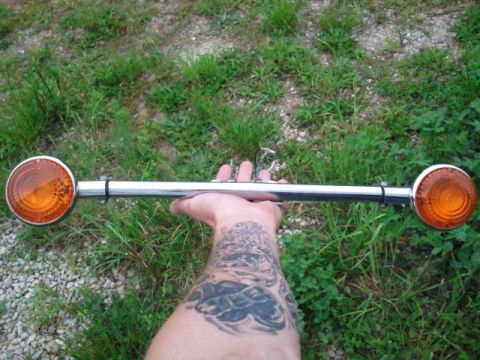 1995 Ford F-150 - A chrome bar with two amber lights is displayed against a grassy background, held by a tattooed arm.