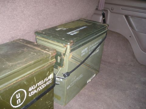 1996 Ford Bronco - Two green ammo cans are stored in the cargo area of a vehicle.