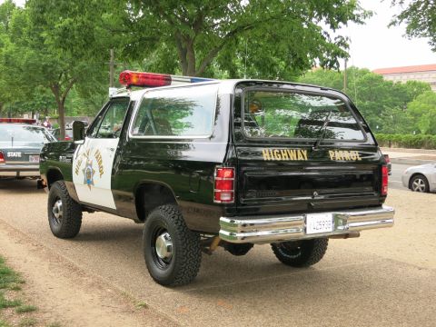 1991 Ford LTD Crown Victoria - Rear three-quarter view of a lifted black-and-white Highway Patrol Dodge Ramcharger SUV with HIGHWAY PATROL lettering and a red-and-blue li…