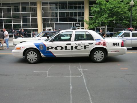 1991 Ford LTD Crown Victoria - white Richmond Police Ford Crown Victoria cruiser marked POLICE 911 sits on an urban street with other patrol cars and people in the backgr…