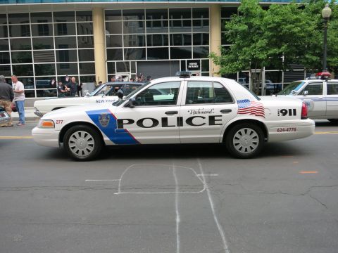 1991 Ford LTD Crown Victoria - white Richmond Police Ford Crown Victoria cruiser with American flag decals and 911 markings sits on a downtown street among other police c…