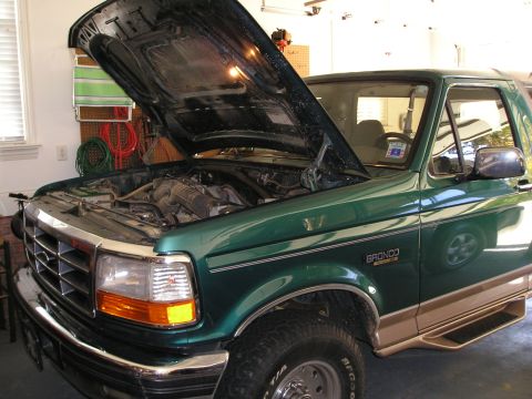 1996 Ford Bronco - 1996 Ford Bronco with hood up, parked indoors. Engine compartment is visible.