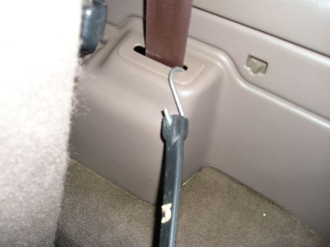 1996 Ford Bronco - Interior shot showing a seatbelt anchor point with a tool attached. The vehicle's model year is not identifiable from this view.