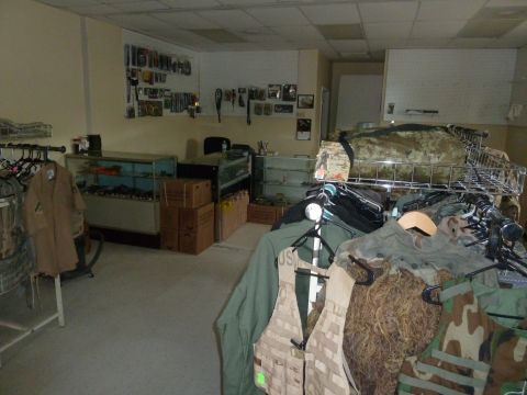 1992 Ford Mustang - A view inside a store displaying various military apparel and equipment on racks and shelves.