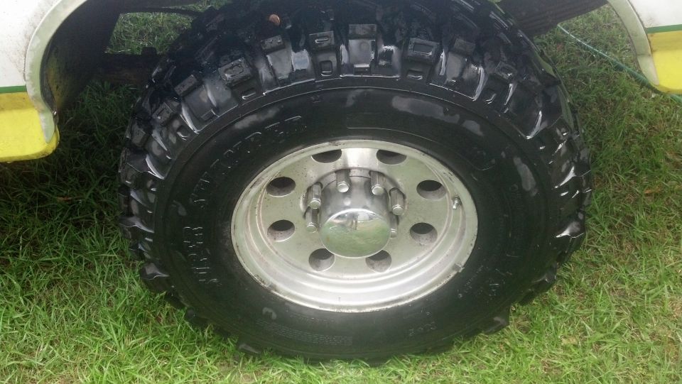 Close-up of a large off-road tire and silver wheel on a vehicle