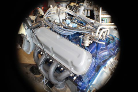 1968 Ford Bronco - Engine components are visible, including spark plug wires and fuel lines, in a workshop setting.