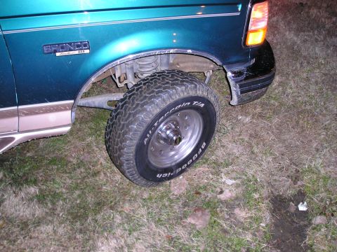 1996 Ford Bronco - Close-up of the front fender and wheel of a green Ford Bronco.
