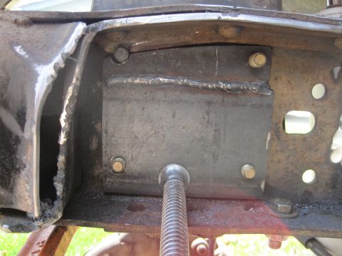 1989 Ford Bronco - A close-up view of a welded metal bracket on a vehicle's frame, showing bolted connections and rough metal edges.