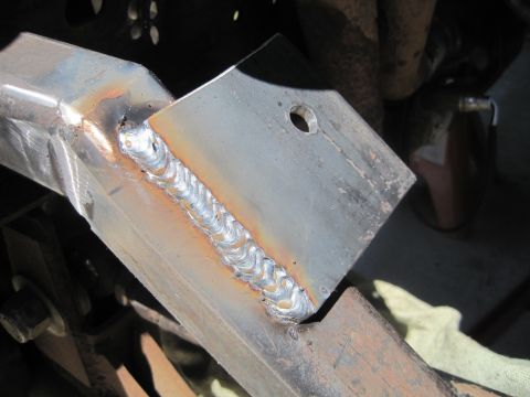 1989 Ford Bronco - Close-up of a freshly welded metal bracket, likely a repair or modification to a vehicle's frame.