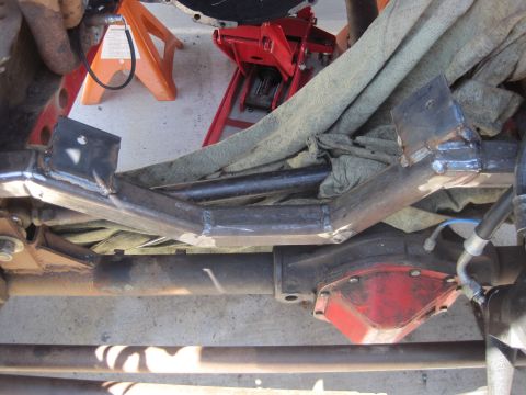 1989 Ford Bronco - Custom fabricated crossmember installed over a red differential housing, with visible suspension components.