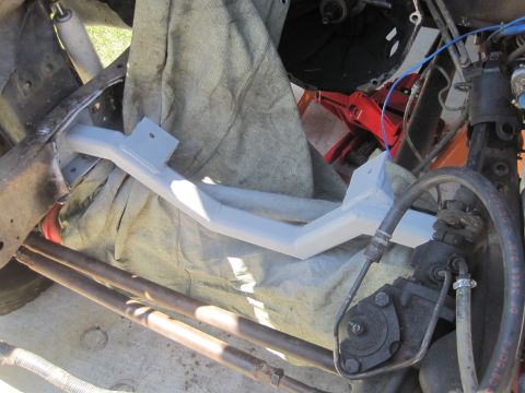 1989 Ford Bronco - Close-up view of a vehicle's undercarriage, showing a painted crossmember and various mechanical parts.