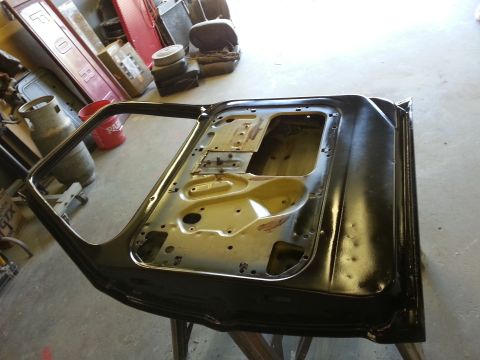 1967 Ford F-100 - Black door for a 1967 Ford F-100 truck, shown disassembled in a workshop.