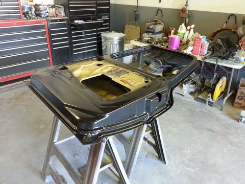 1967 Ford F-100 - Car door undergoing restoration in a workshop setting, surrounded by tools and equipment.