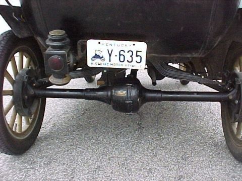 1909 Ford Model T - The rear axle and suspension system of a vintage automobile are visible, along with a license plate.