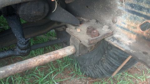 1983 Ford F-250 - Close-up view of a vehicle's front suspension components and tire tread, likely for parts.