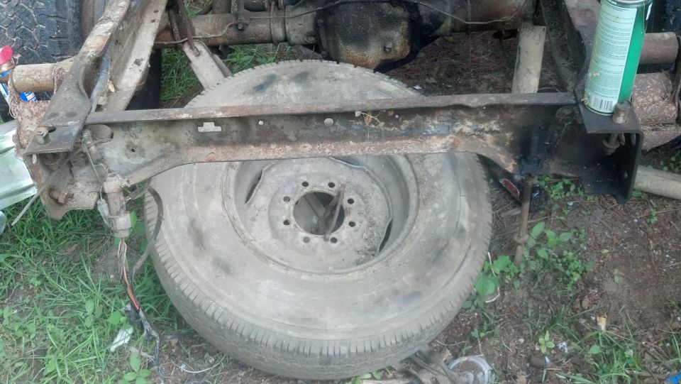 Close-up of a truck frame section with a spare tire mounted