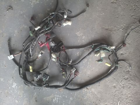 2005 Dodge 3500 - A complex automotive wiring harness is displayed on a concrete surface, showing various connectors and a fuse block.