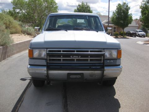 1988 Ford Bronco - Front view of a gray Ford Bronco parked on a street.