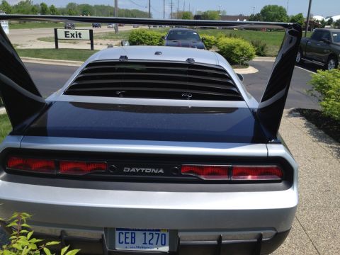 1988 Ford Bronco - Rear view of a silver car a prominent rear wing and 'DAYTONA' badging, with horizontal louvers on the rear window.