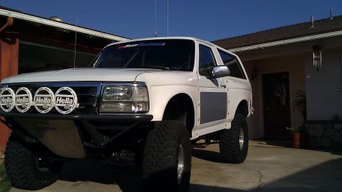 1996 Ford Bronco - Modified 1996 Ford Bronco with off-road lights and custom body panels parked in a driveway.