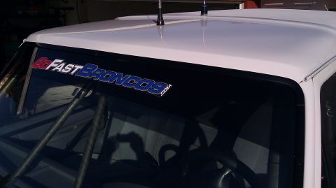 1996 Ford Bronco - The interior of a white vehicle shows a "Go Fast Broncos" banner on the windshield and a roll cage.