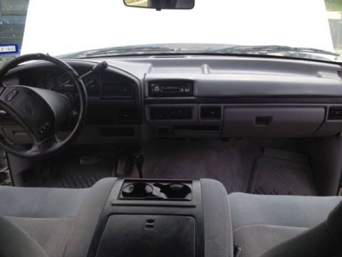 1997 Ford F-350 - The interior of a 1997 Ford F-350 shows a gray dashboard, steering wheel, and seats.