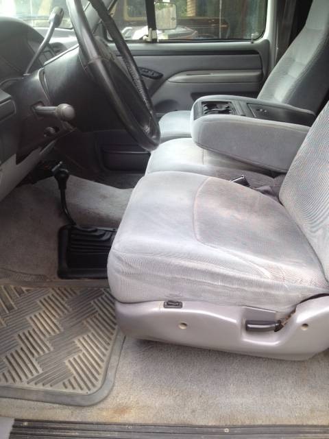 1997 Ford F-350 - The interior of a truck shows the driver's seat, passenger seat, and dashboard area.