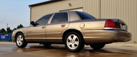 2005 Ford Crown Victoria - This gold 2005 Ford Crown Victoria is shown from the rear three-quarter angle.