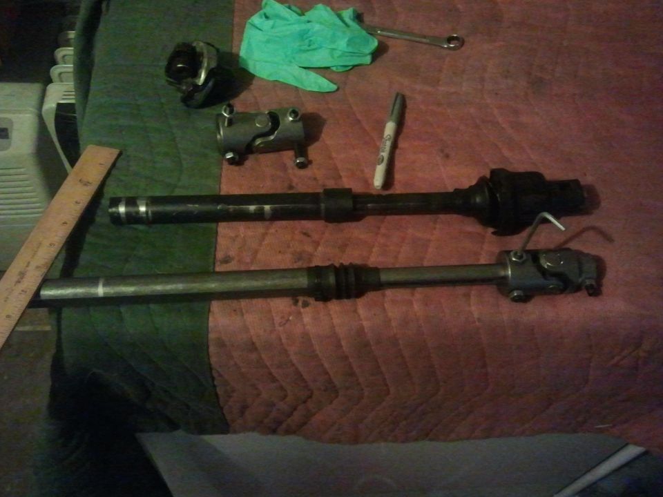 Two steering columns and U-joints with a ruler and marker