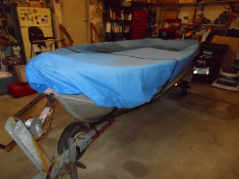 1996 Ford F-150 - A boat covered in a blue tarp sits on a trailer inside a garage.