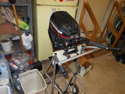 1996 Ford F-150 - A Gamefisher outboard motor is mounted on a stand in a cluttered garage setting.
