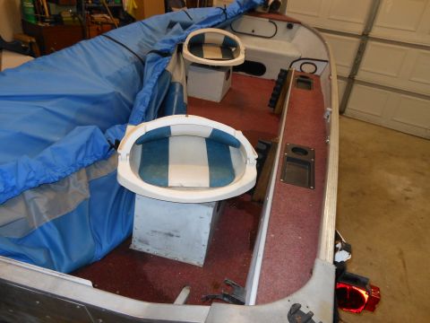 1996 Ford F-150 - The interior of a boat is shown, partially covered by a blue tarp, with two seats visible.