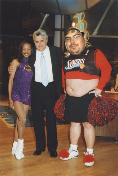 1991 Ford LTD Crown Victoria - Jay Leno is pictured with two individuals in costumes, one dressed as a Lakers fan and the other as a 76ers fan.
